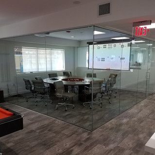 A conference room with a table and chairs and a projector screen.