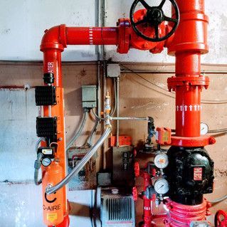 A bunch of red pipes are connected to each other in a room.