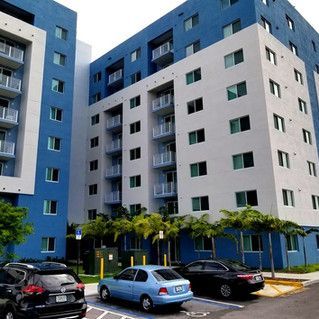A blue and white building with cars parked in front of it