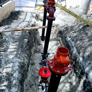 A bunch of pipes are being installed in a trench.