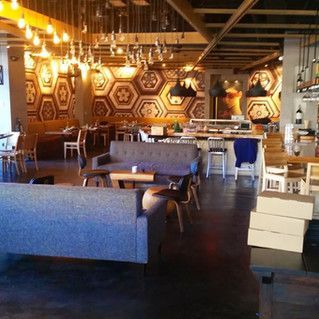 There is a couch in the middle of the room in a restaurant.