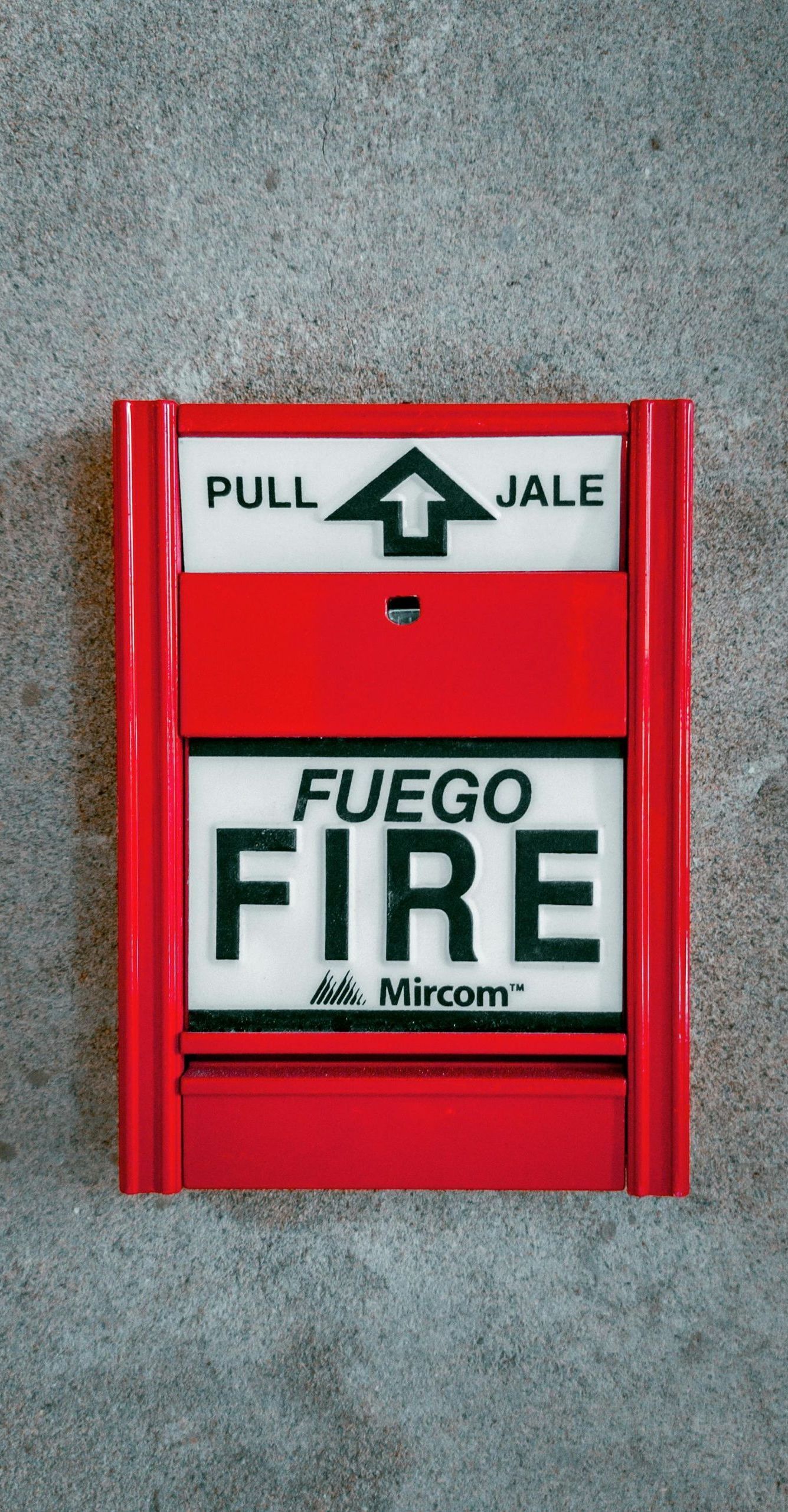 A red fire alarm that says fuego fire on it