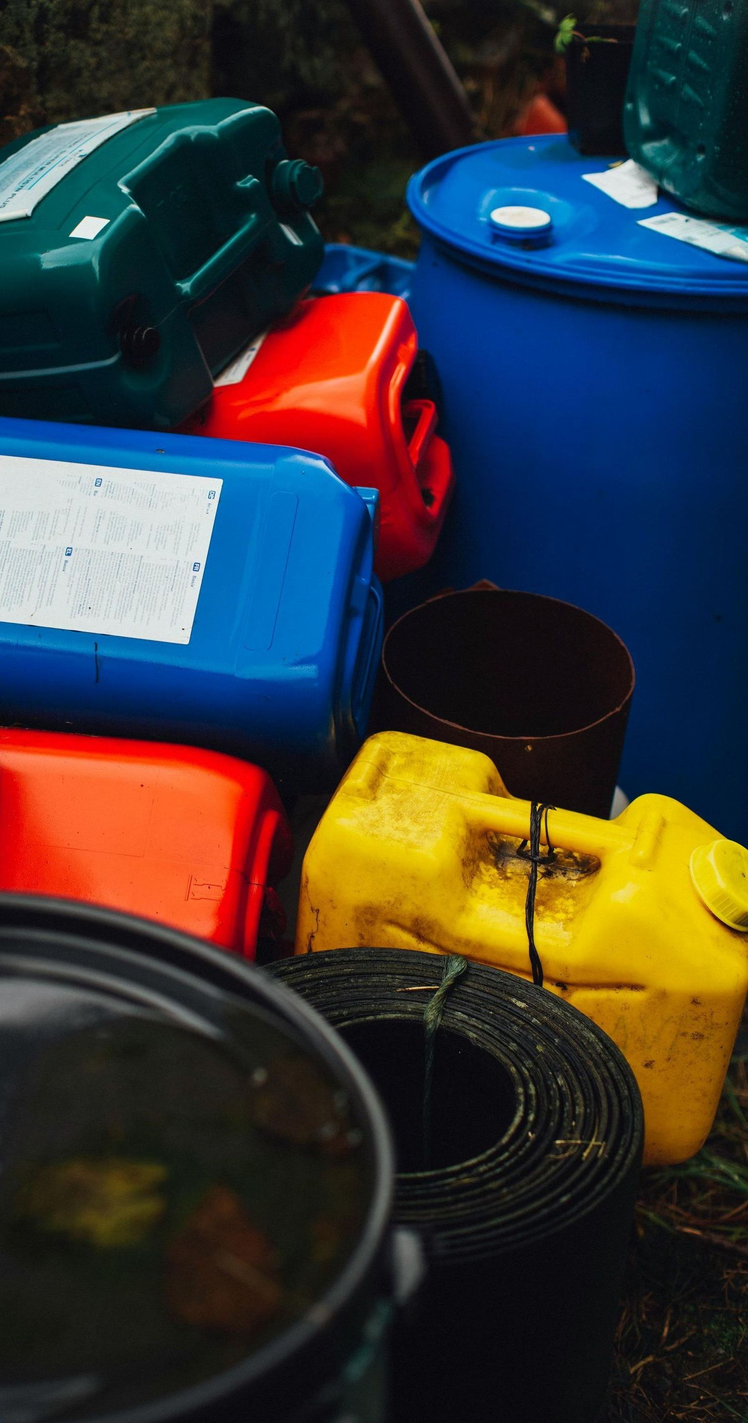 A bunch of colorful plastic barrels are stacked on top of each other.