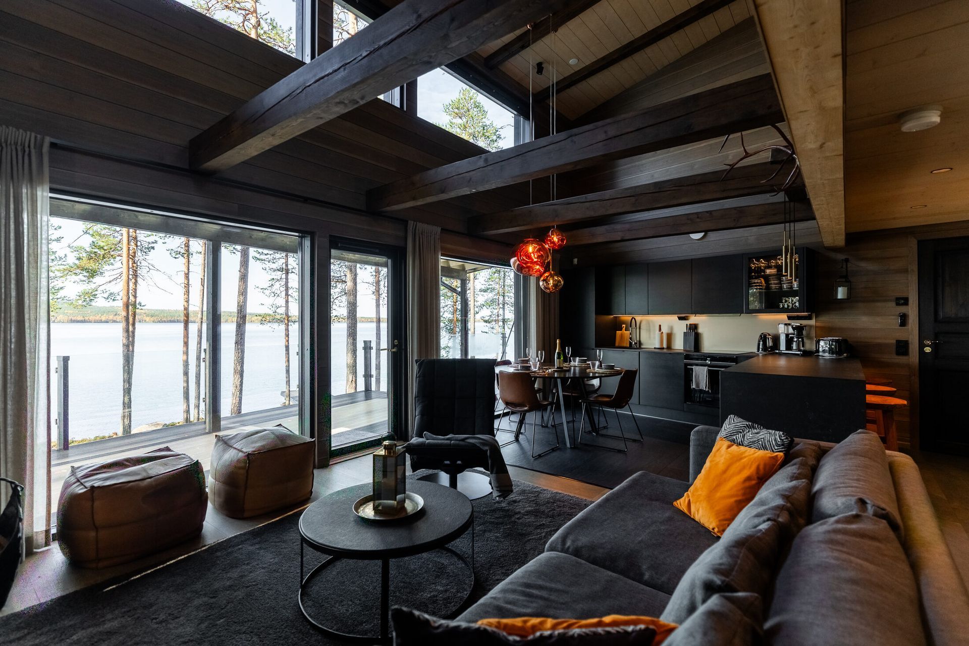 Living room of a lakeside holiday home near Rovaniemi with a fireplace and lake view