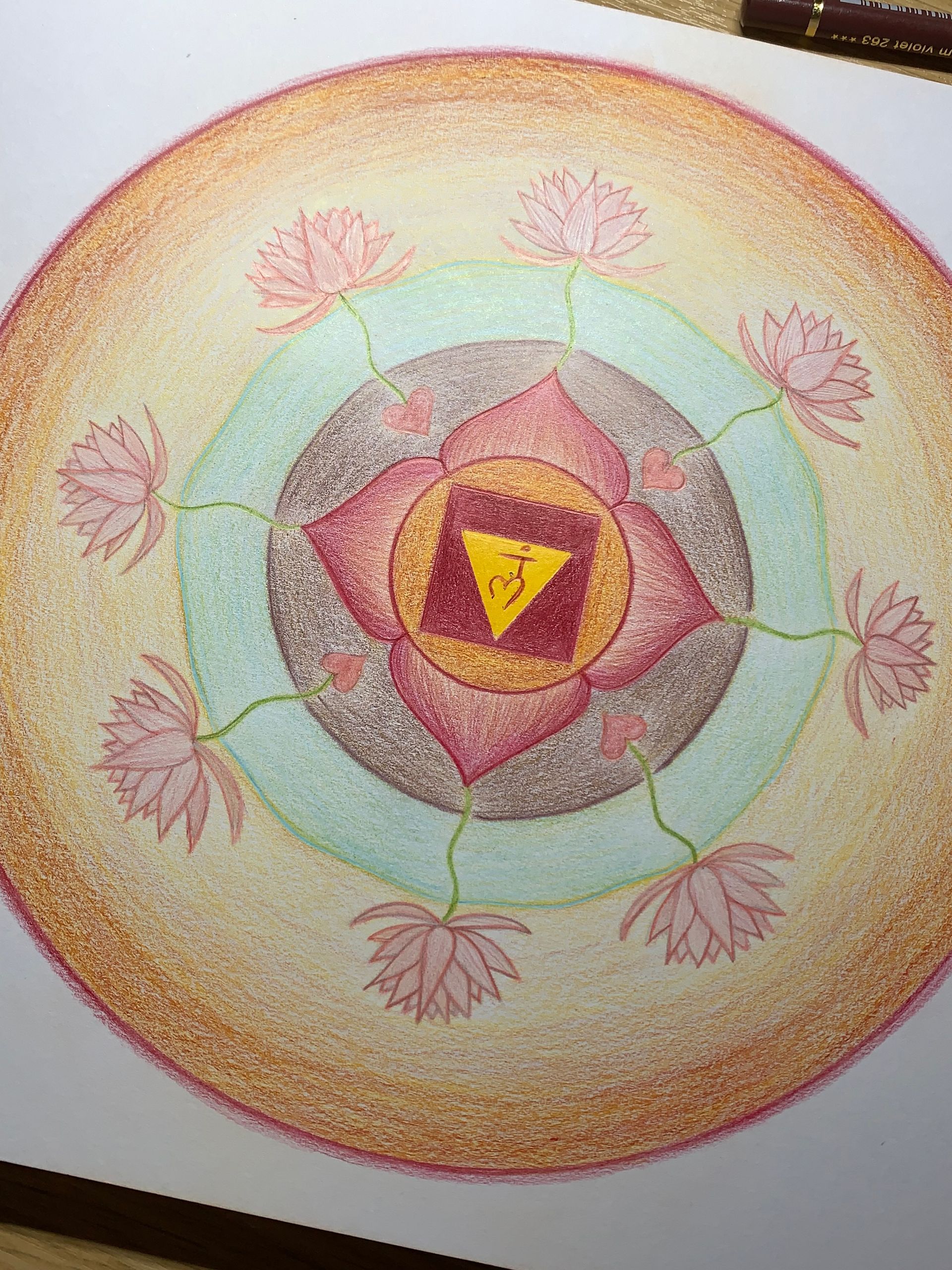 Colorful mandala drawing with pink lotus flowers, a triangle, and concentric circles.