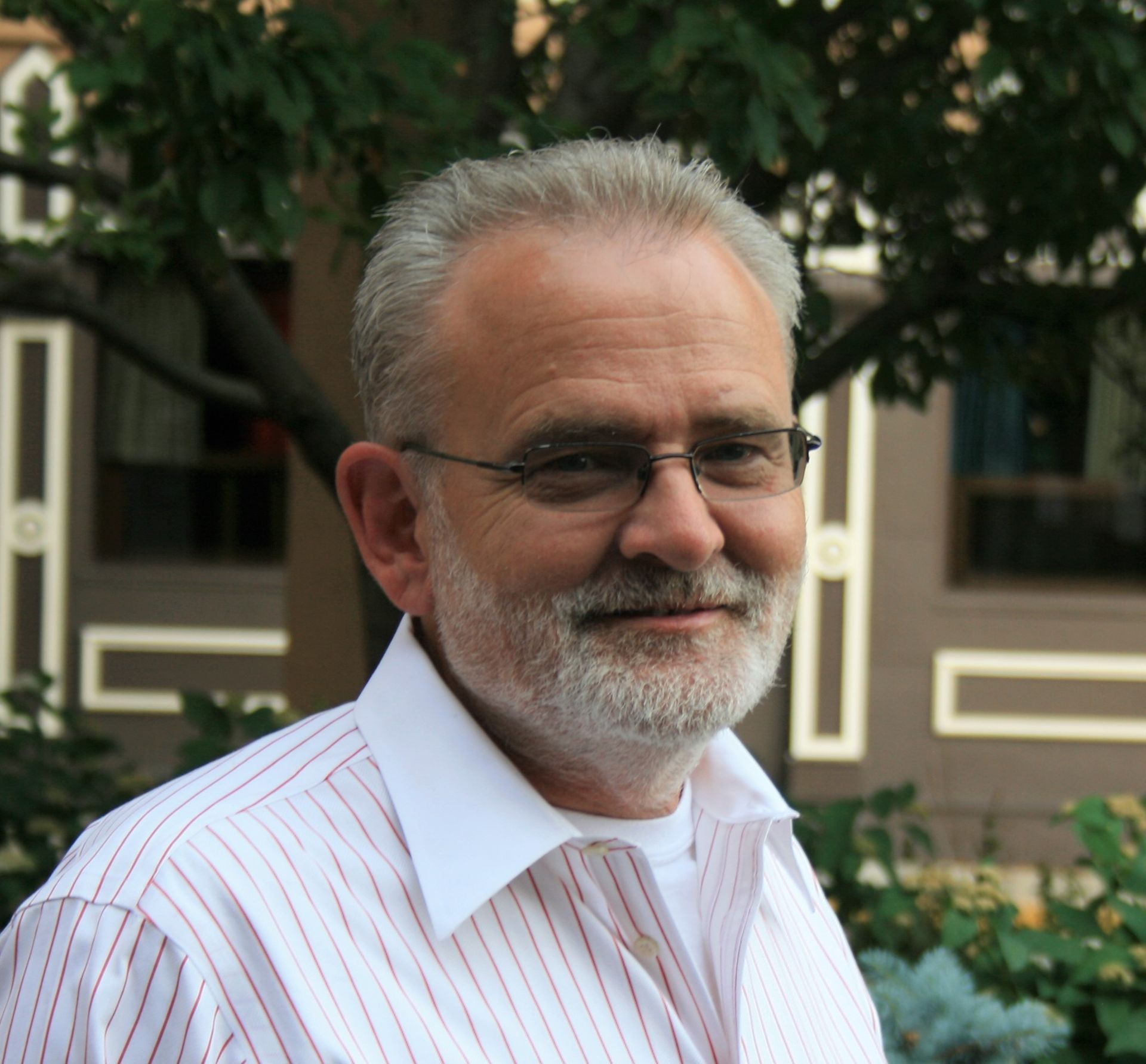 Richard Nielsen with glasses and a beard is wearing a striped shirt