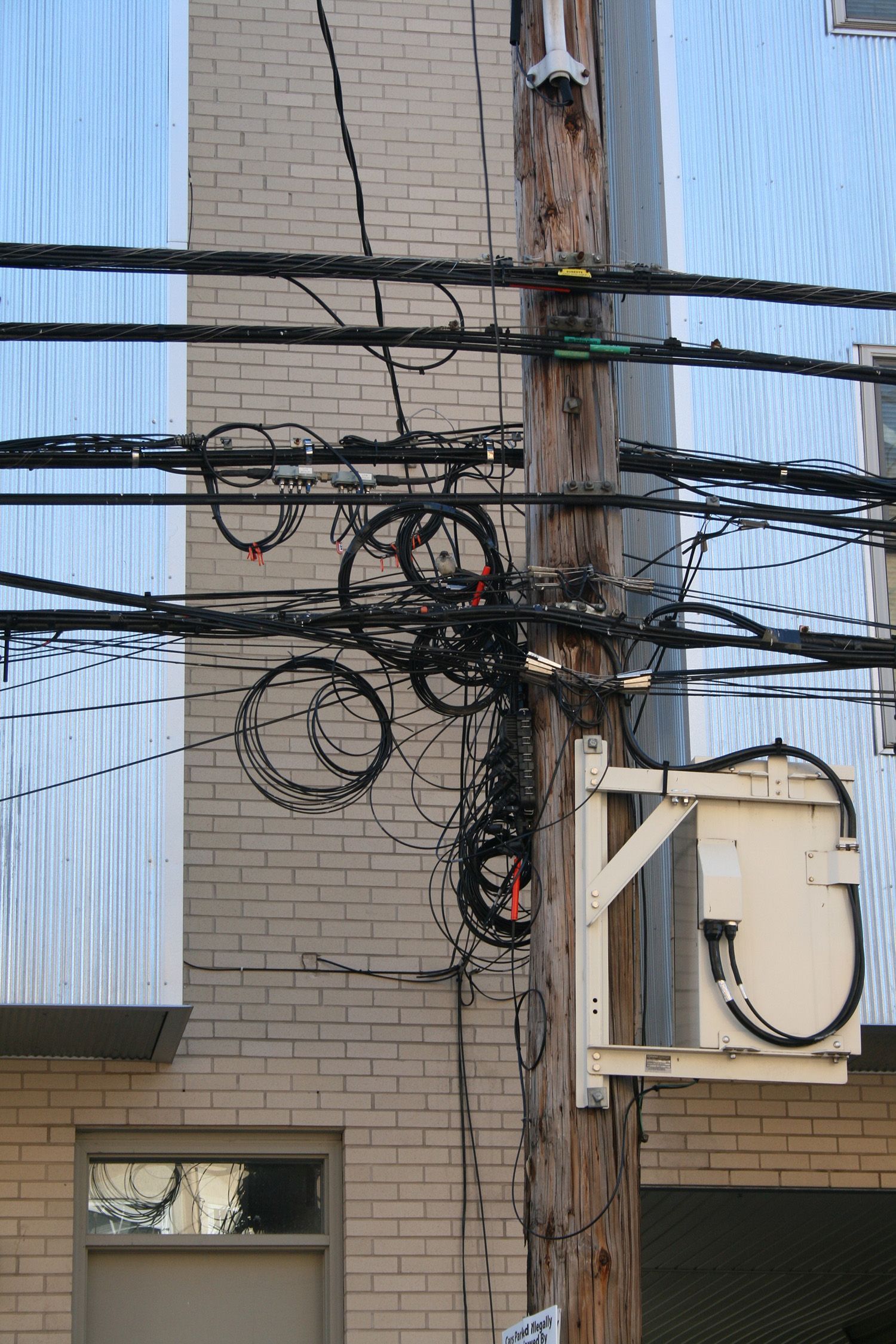 A telephone pole with a bunch of wires attached to it
