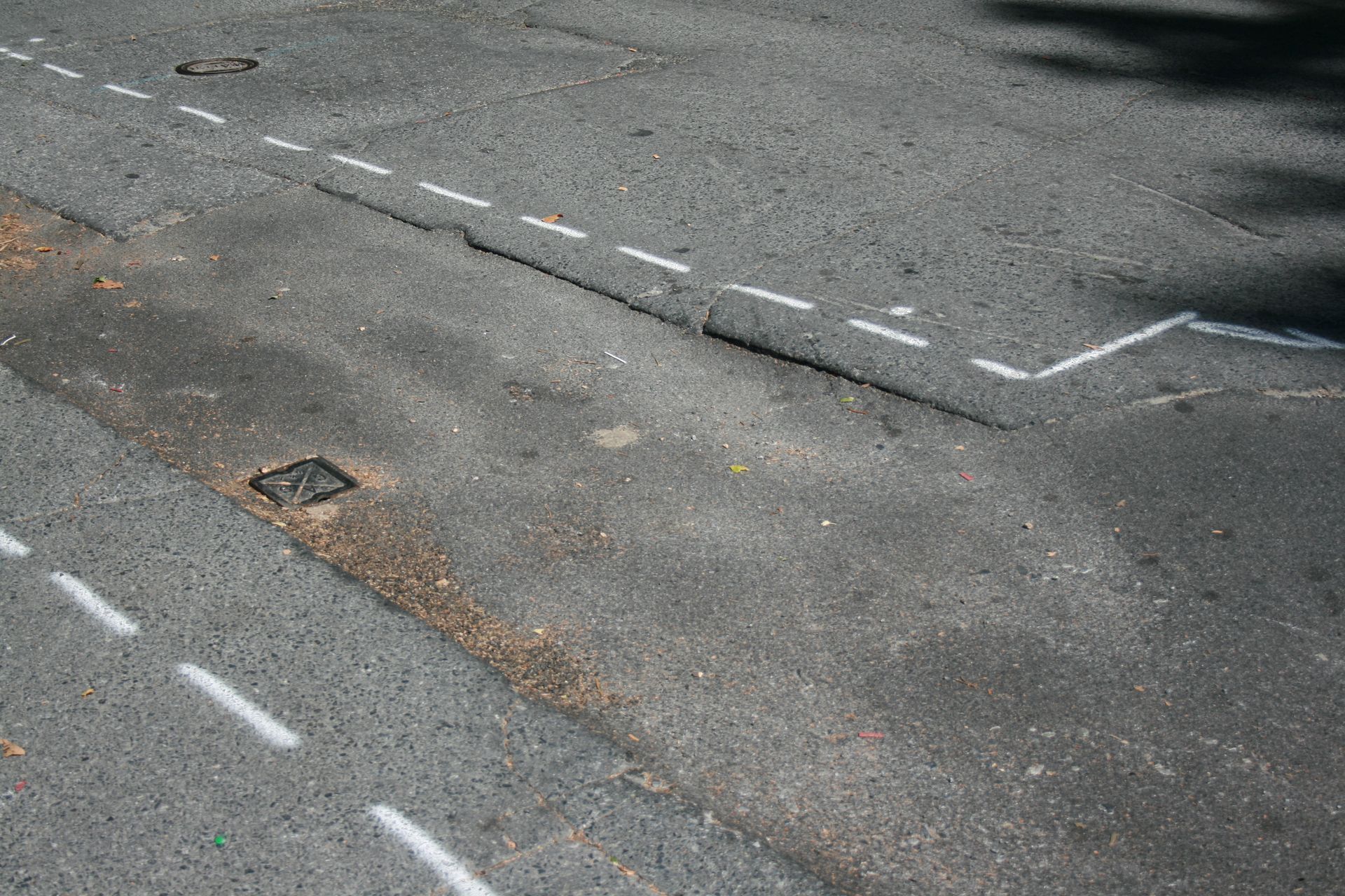A gray asphalt road with white lines on it