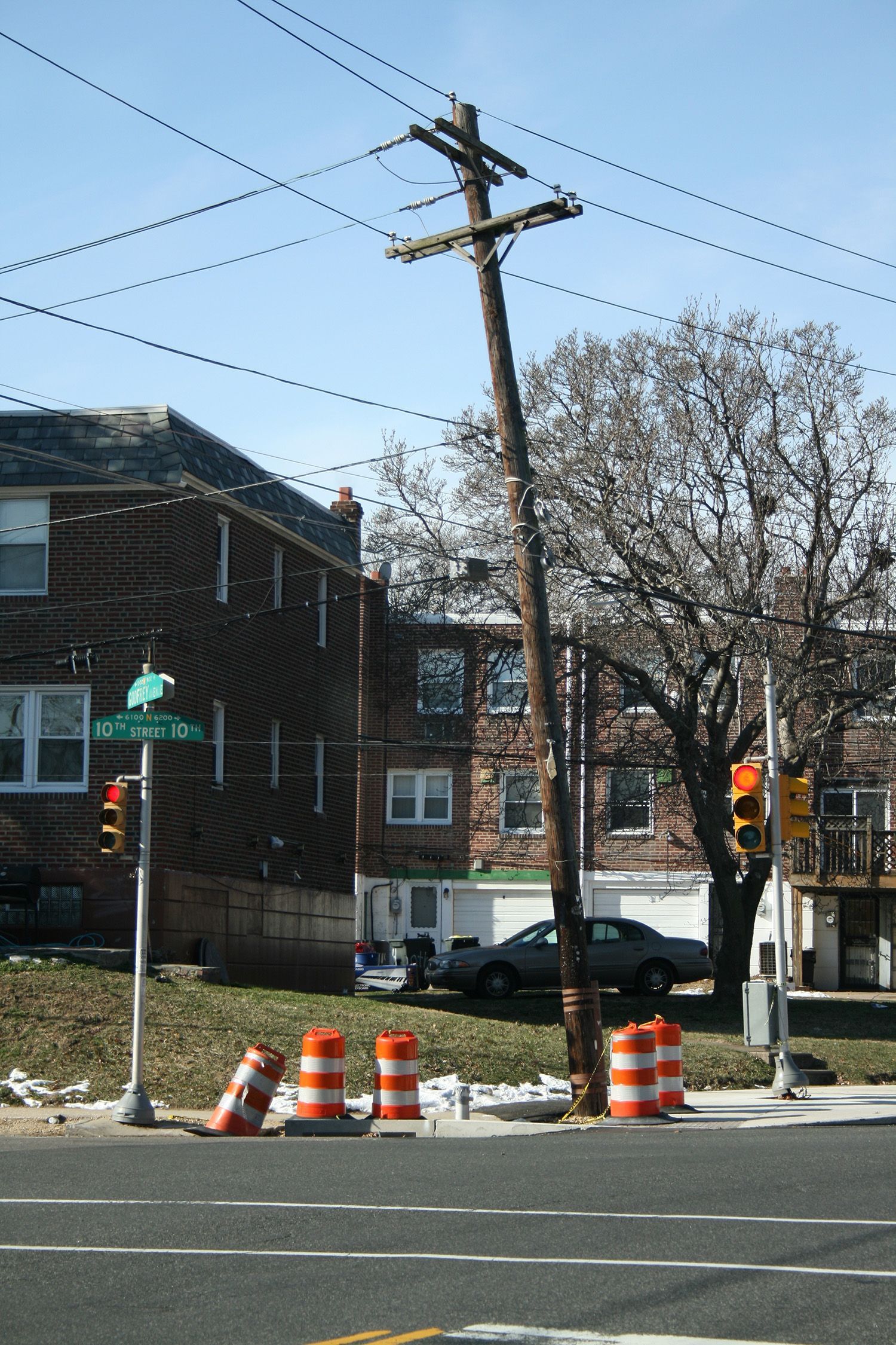 A telephone pole is leaning over the side of the road