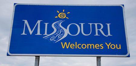 A blue missouri welcomes you sign against a cloudy sky