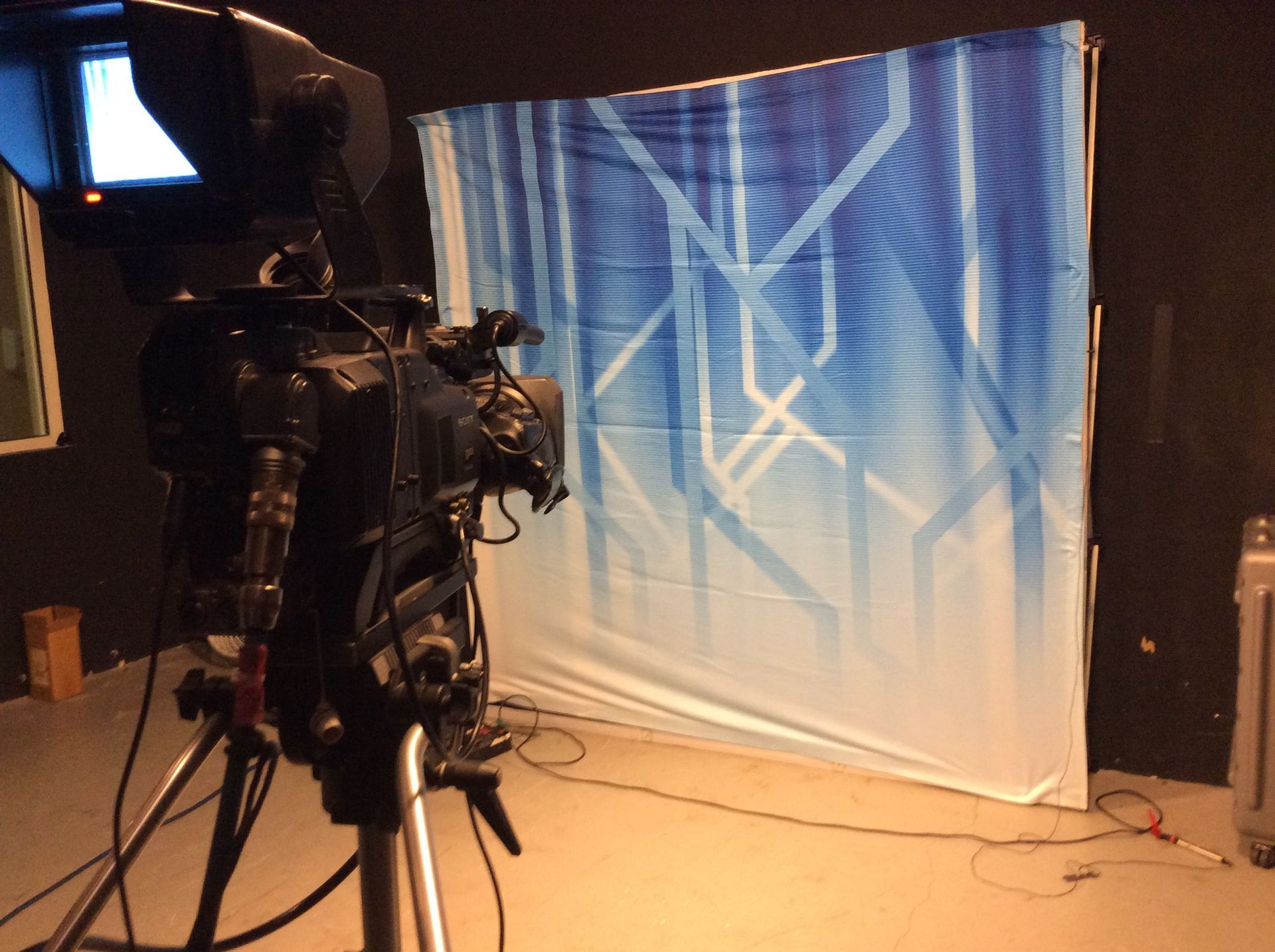 A camera is sitting in front of a blue and white backdrop