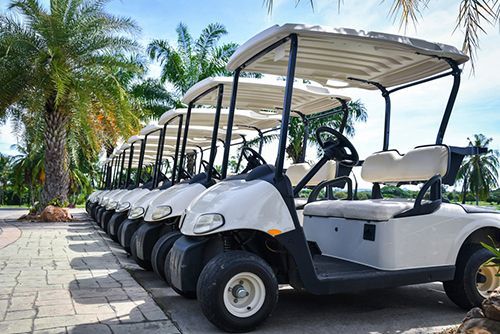 A Row Of Golf Carts Parked Next To Each Other On A Sidewalk — Too Ezy Auto Electrics In Townsville, QLD