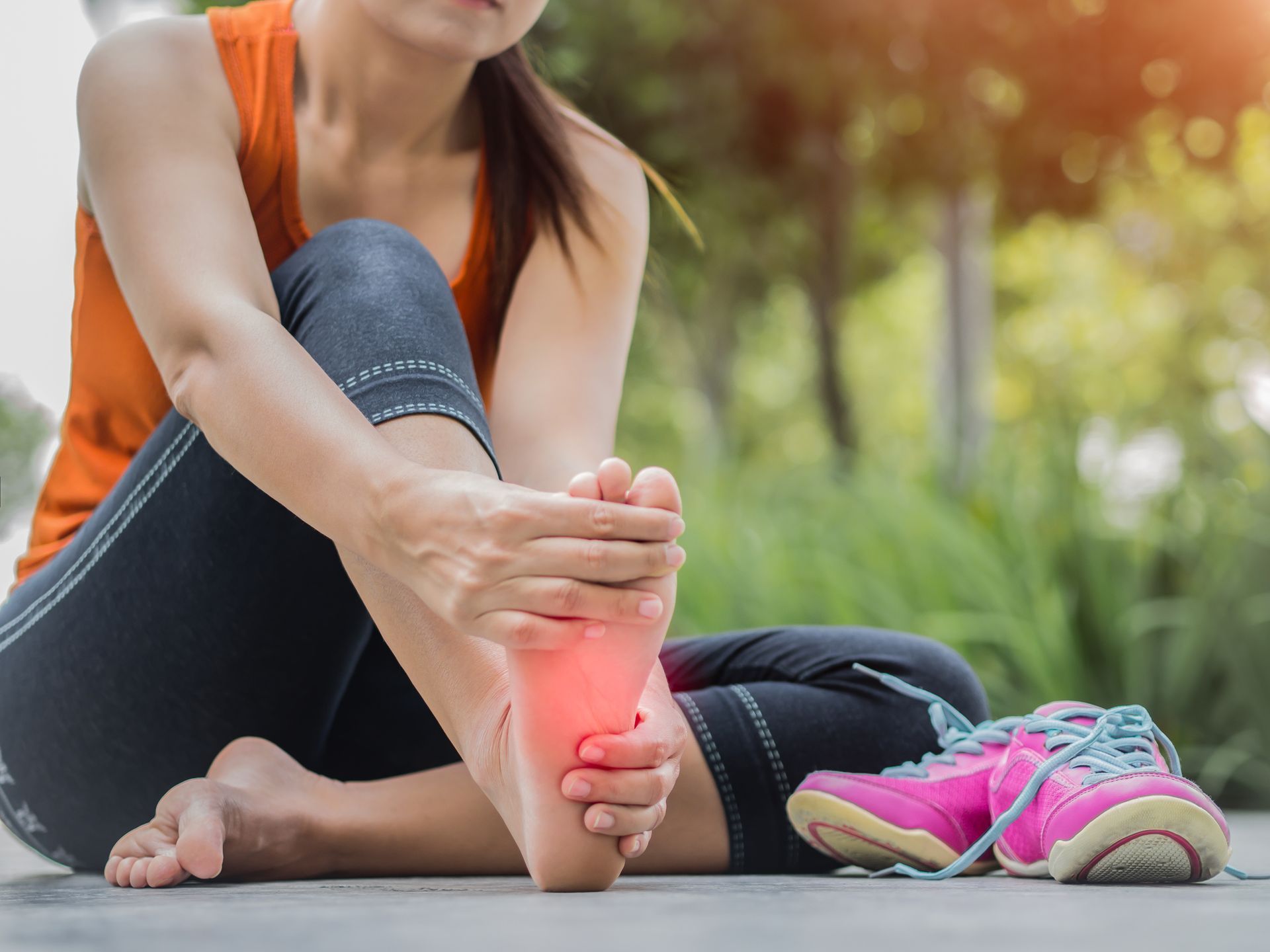 A person is touching their foot with their hands.