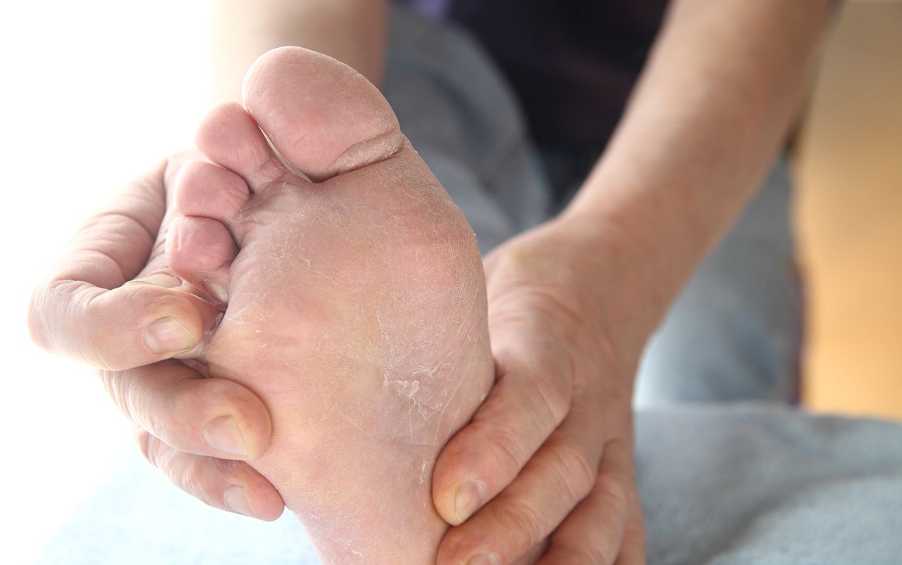 A person is holding their foot in their hands.