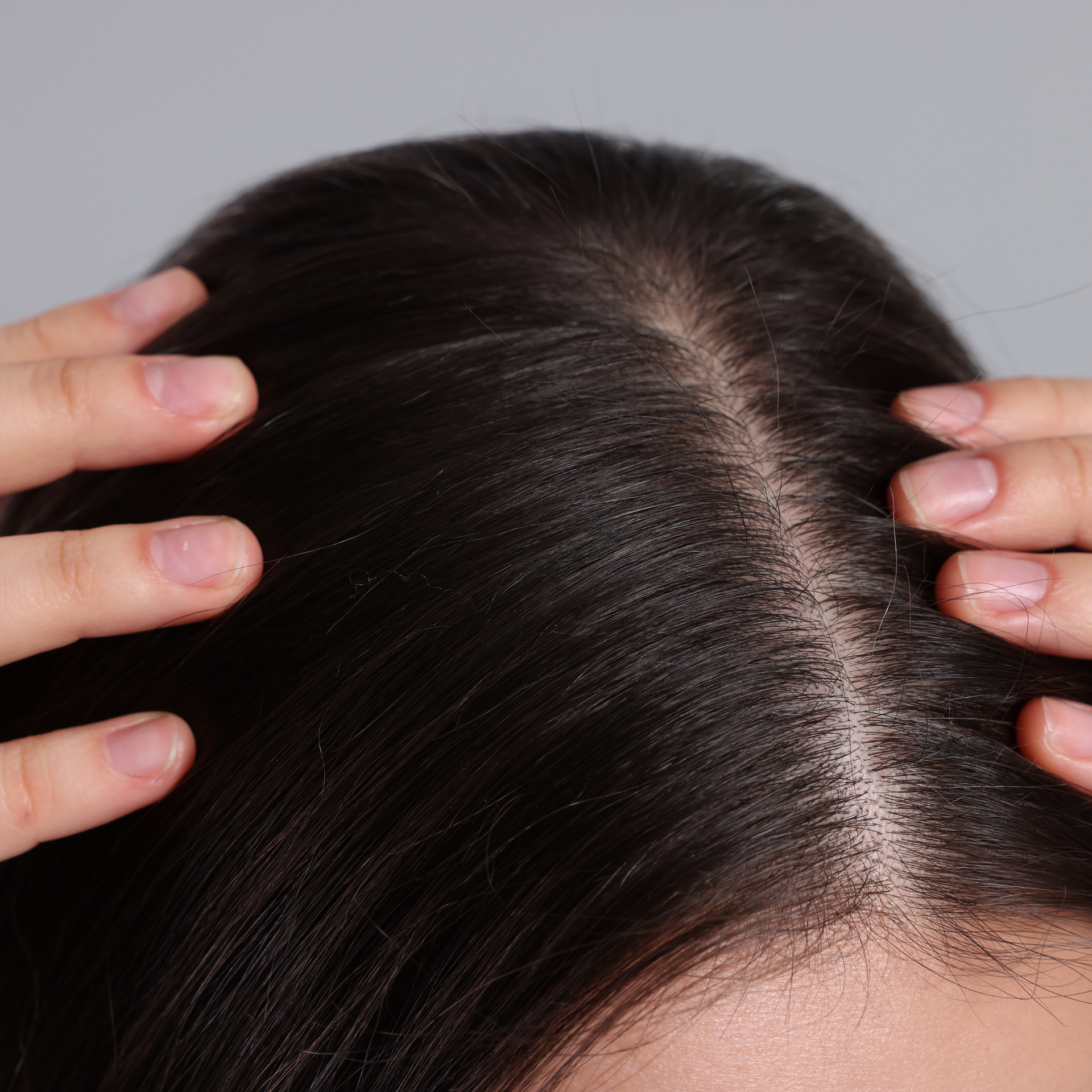 A woman is touching her hair with her hands