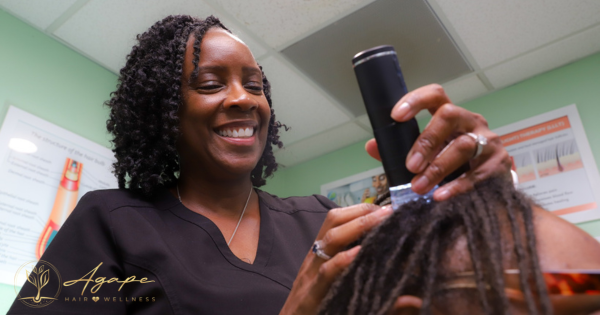 A woman is smiling while holding a brush in her hand.