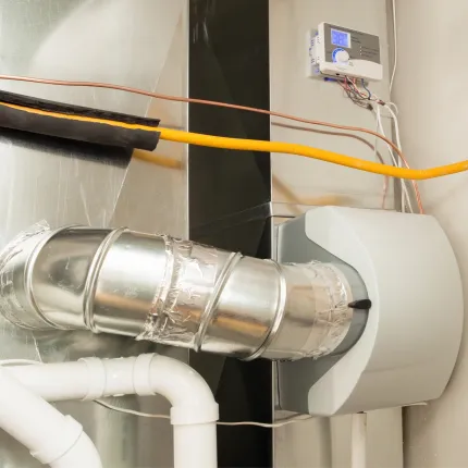 A close up of a ventilation system with a thermostat on the wall