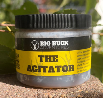 Big Buck Adventures “The Agitator” bait jar with black lid and yellow label outdoors