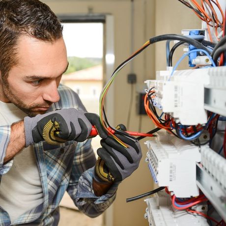 electrician working with wires on panel