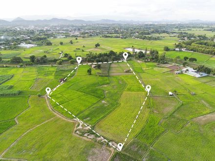 Aerial view of green fields marked with white location pins outlining a polygonal shape.