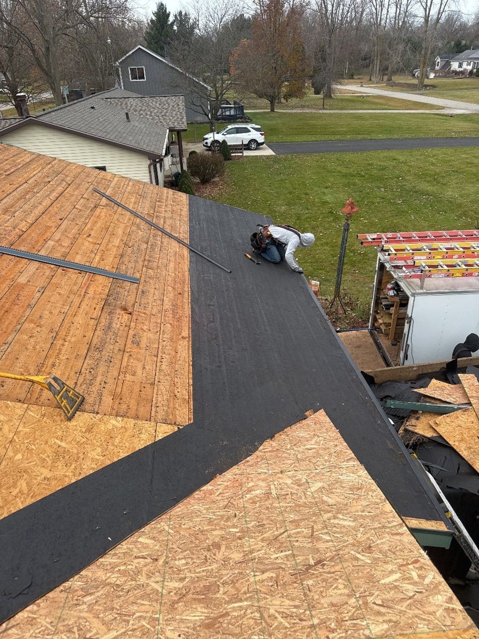 A roofing contractor working on professional roof repairs. A roofing contractor working on professional roof repairs.