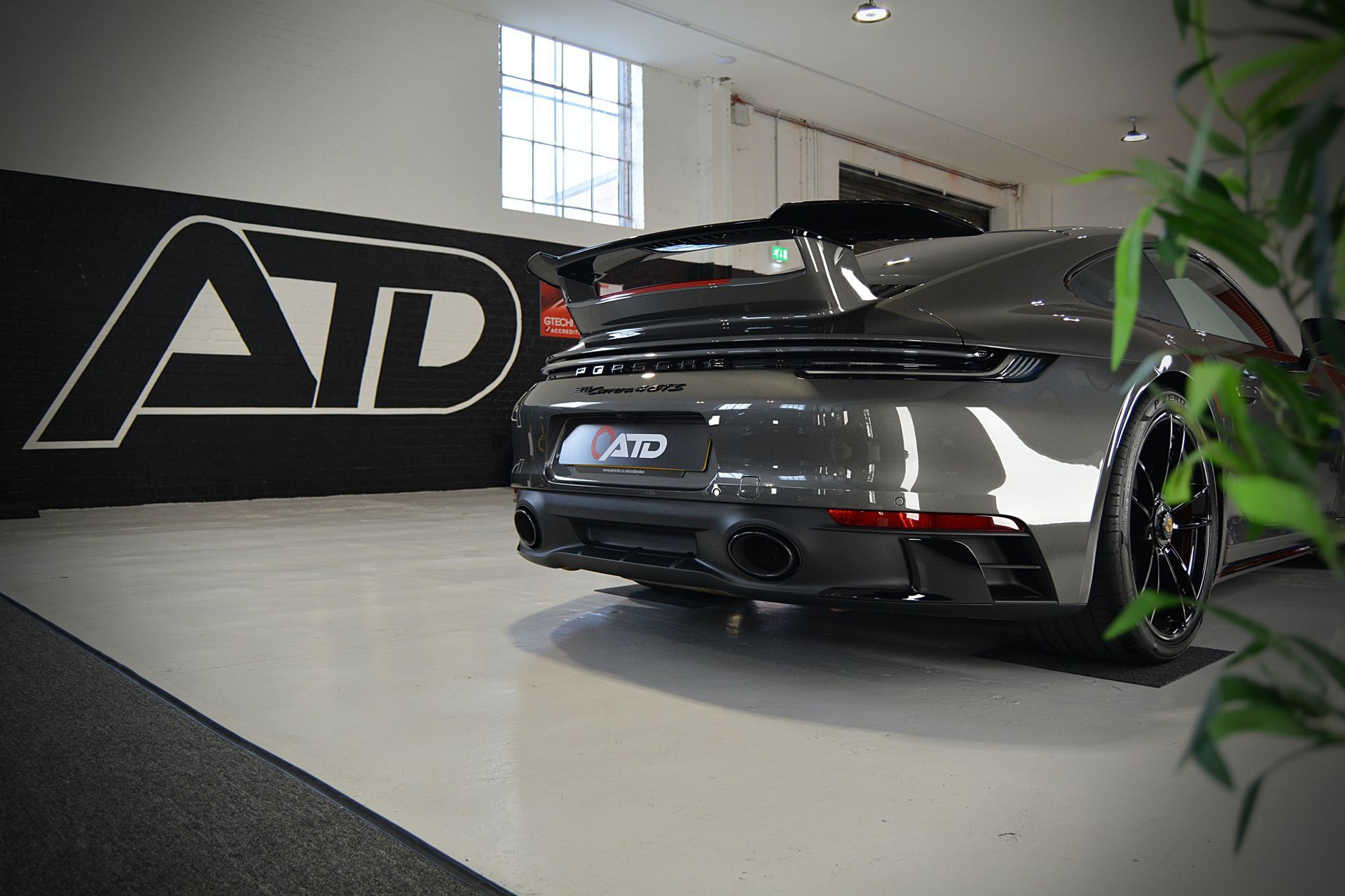 A car is parked in front of a wall that says ad