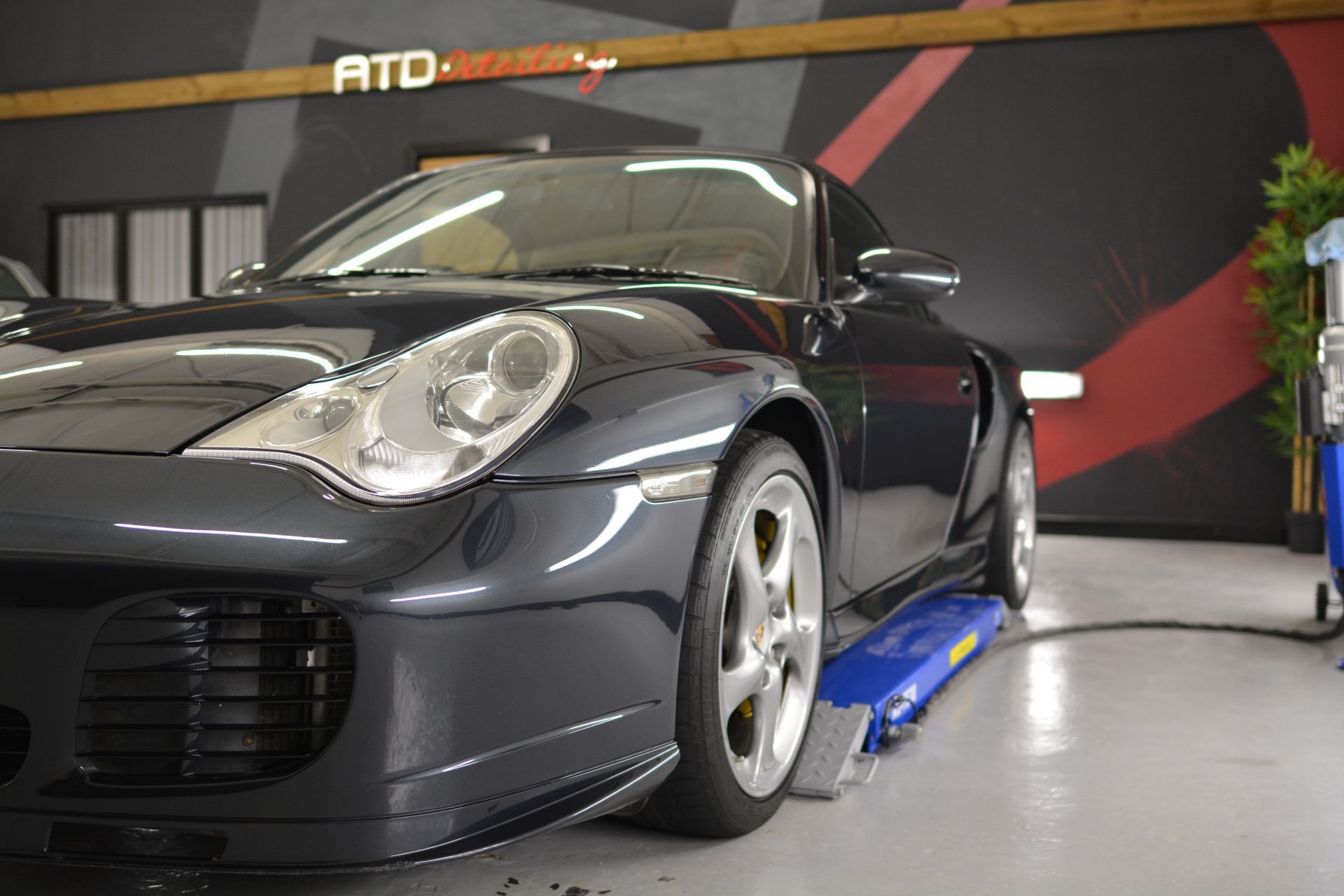 A black sports car is parked on a lift in a garage.