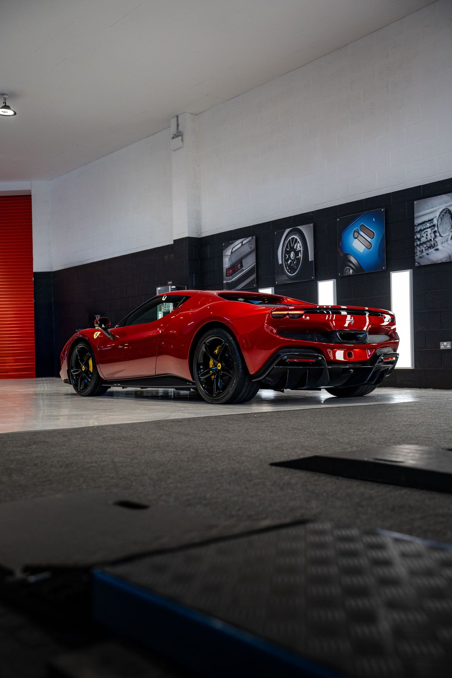 A red sports car is parked in a garage.