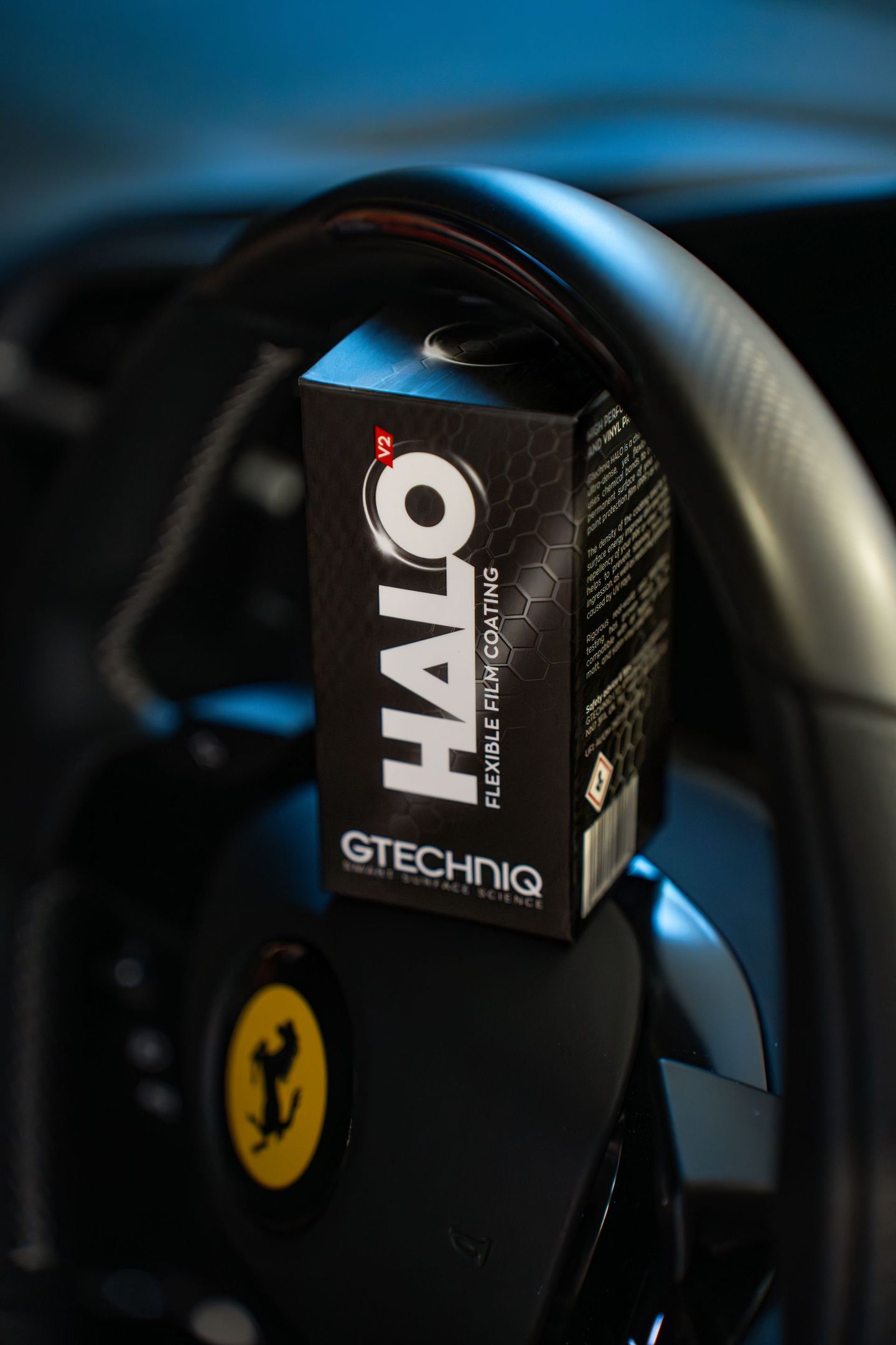 A box of halo is sitting on the steering wheel of a car.