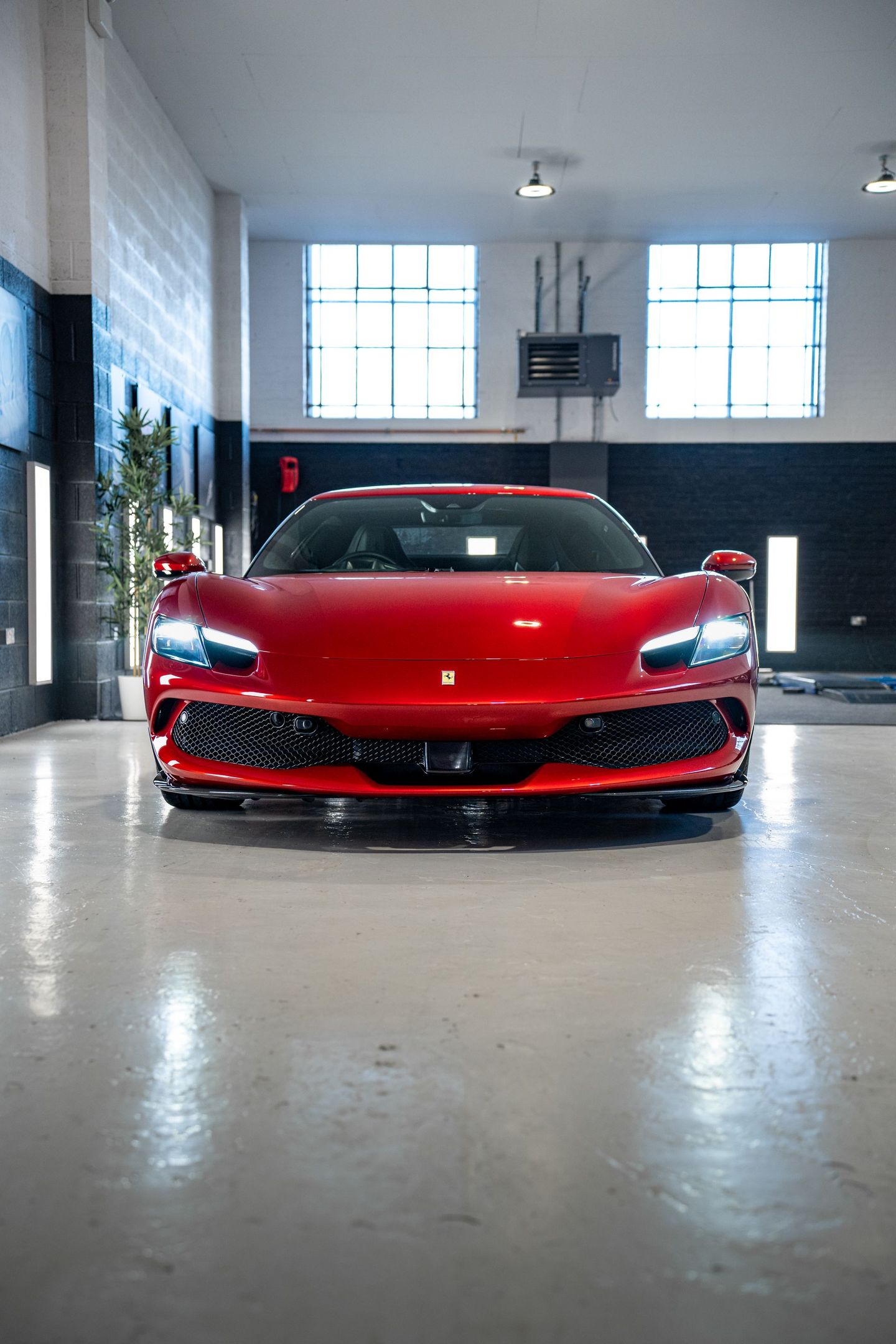 A red sports car is parked in a garage.