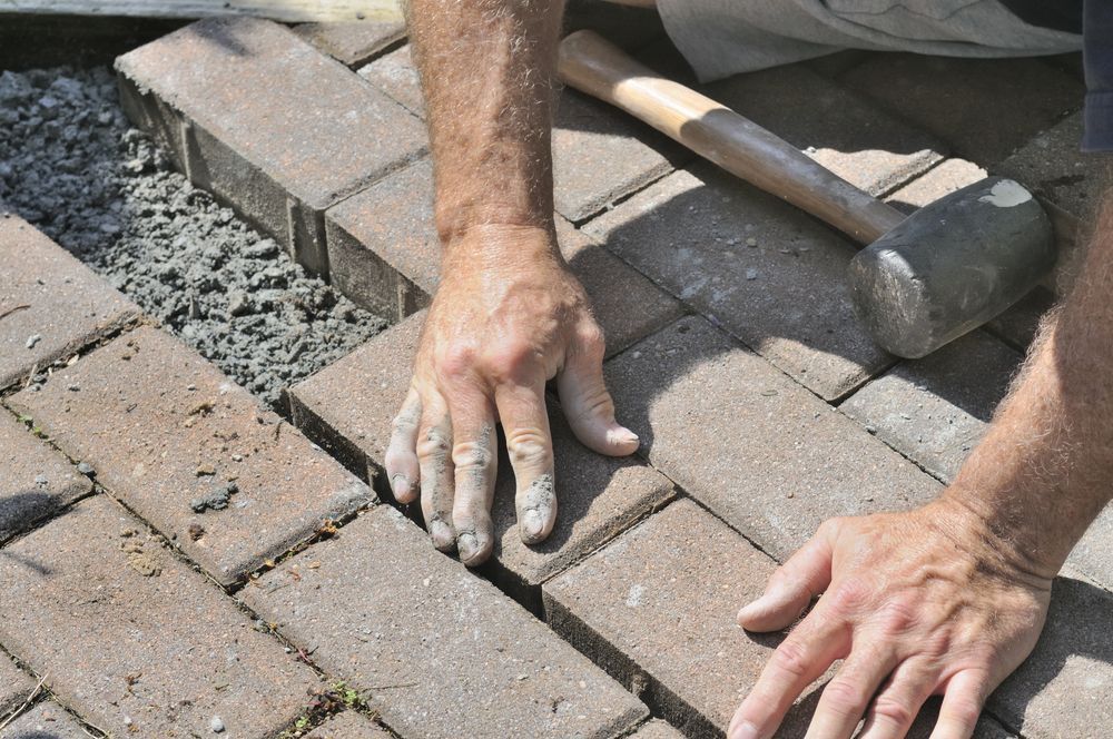Person Laying Brick Pavers — Laurieton Landscape Supplies In Kew, NSW