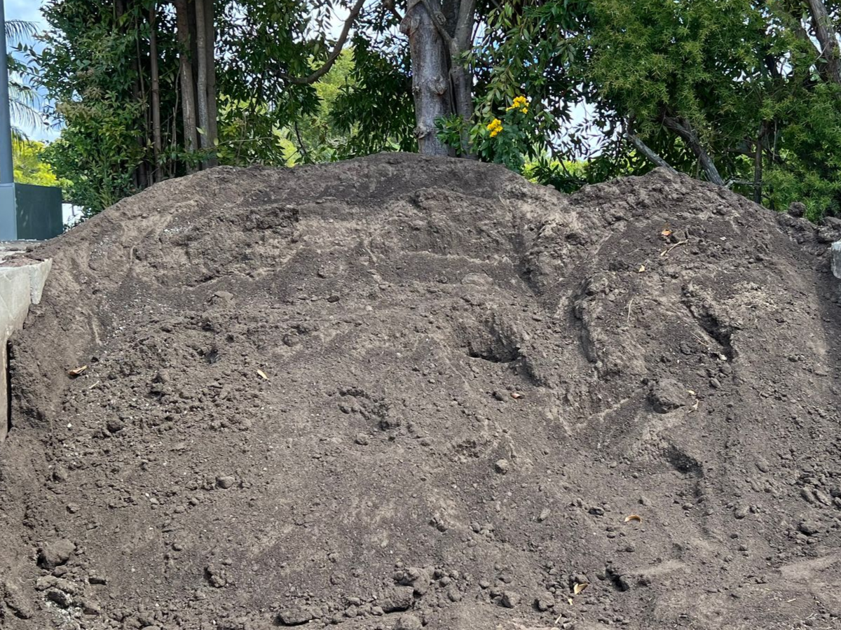 A large mound of dark, coarse soil piled in an outdoor area — Laurieton Landscape Supplies In Harrington, NSW