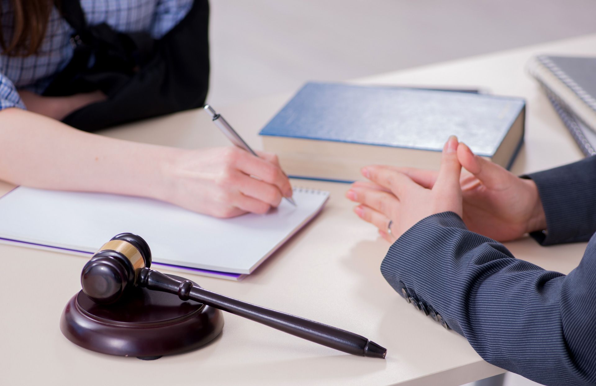 A man and a woman are sitting at a table with a judge's gavel