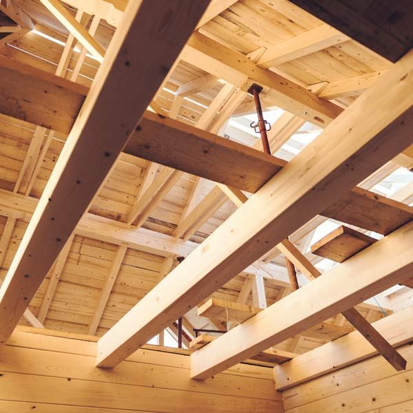 Wooden ceiling framing with exposed beams and skylight opening above unfinished interior walls