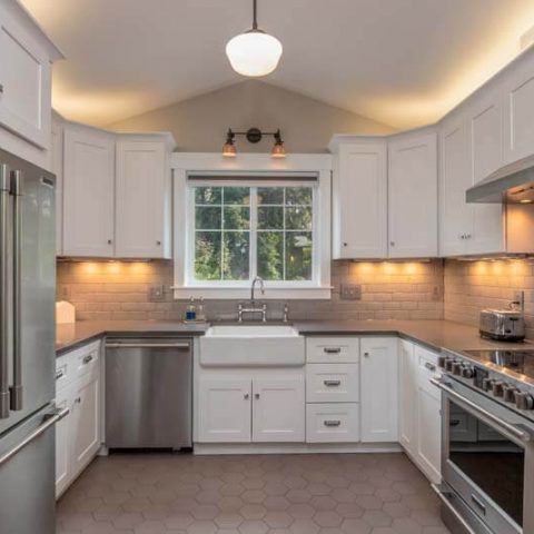 Bright modern kitchen with white cabinets, subway tile backsplash, farmhouse sink, and stainless steel appliances