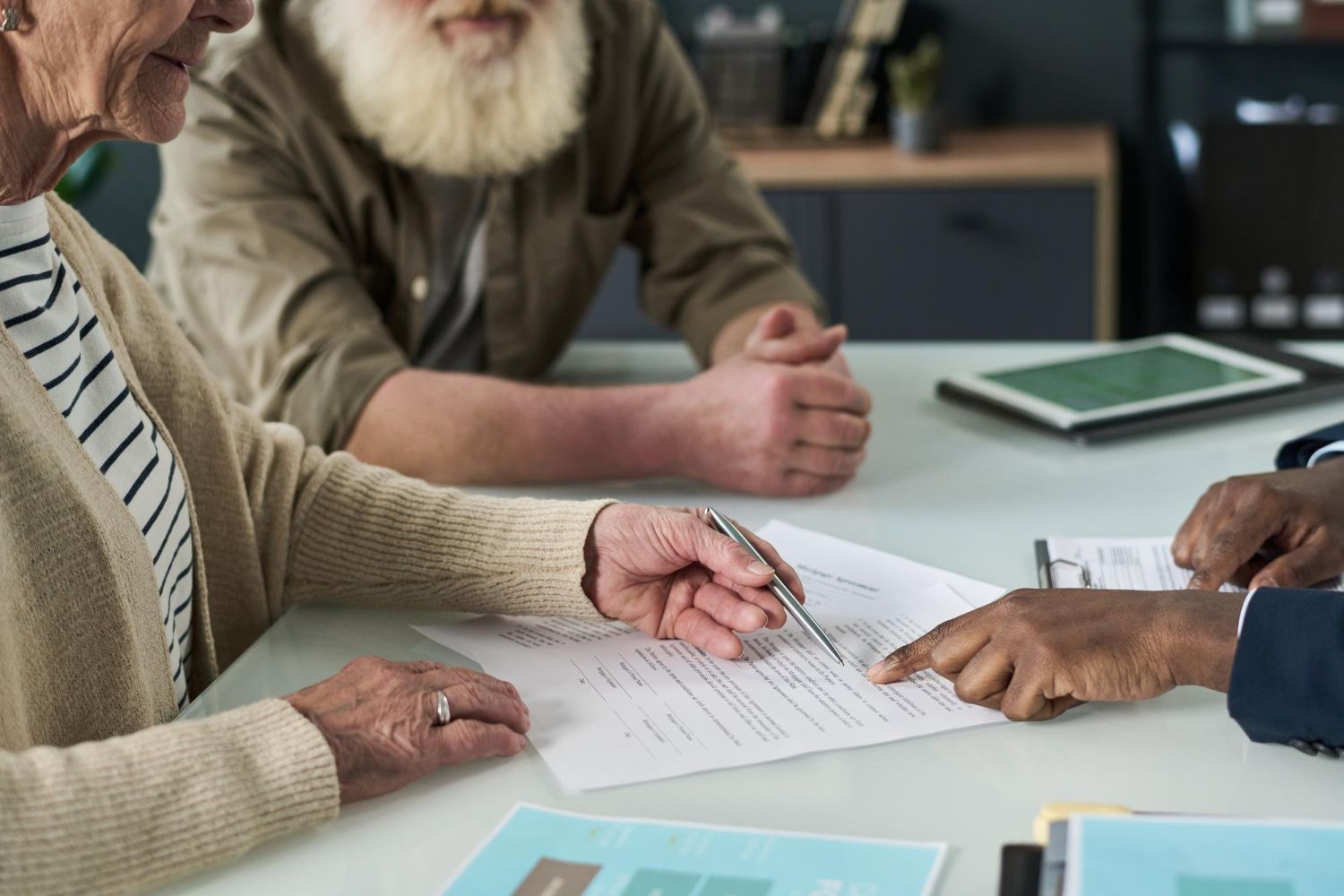 People reviewing a document at a table, with one person pointing and others listening attentively.
