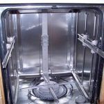 The inside of a stainless steel dishwasher with the door open.