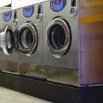 A row of washing machines are lined up in a laundromat.