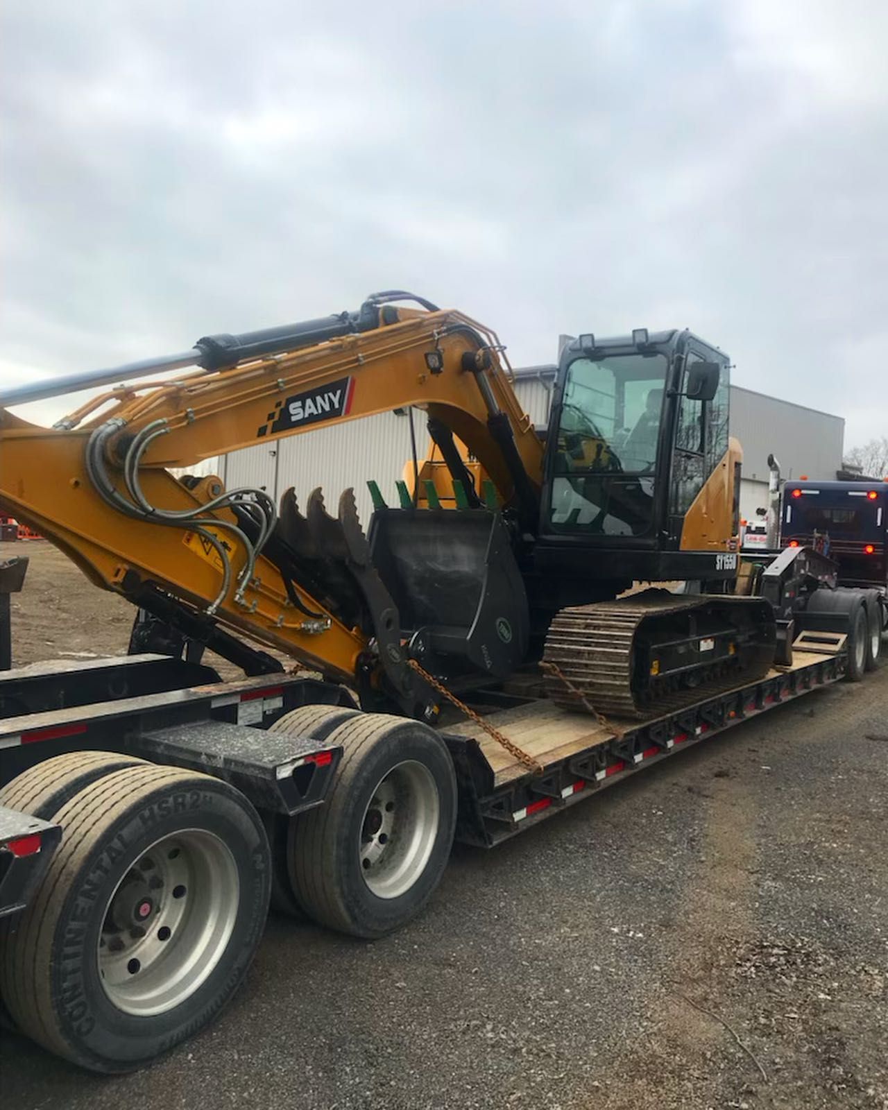 A yellow excavator is sitting on top of a trailer.
