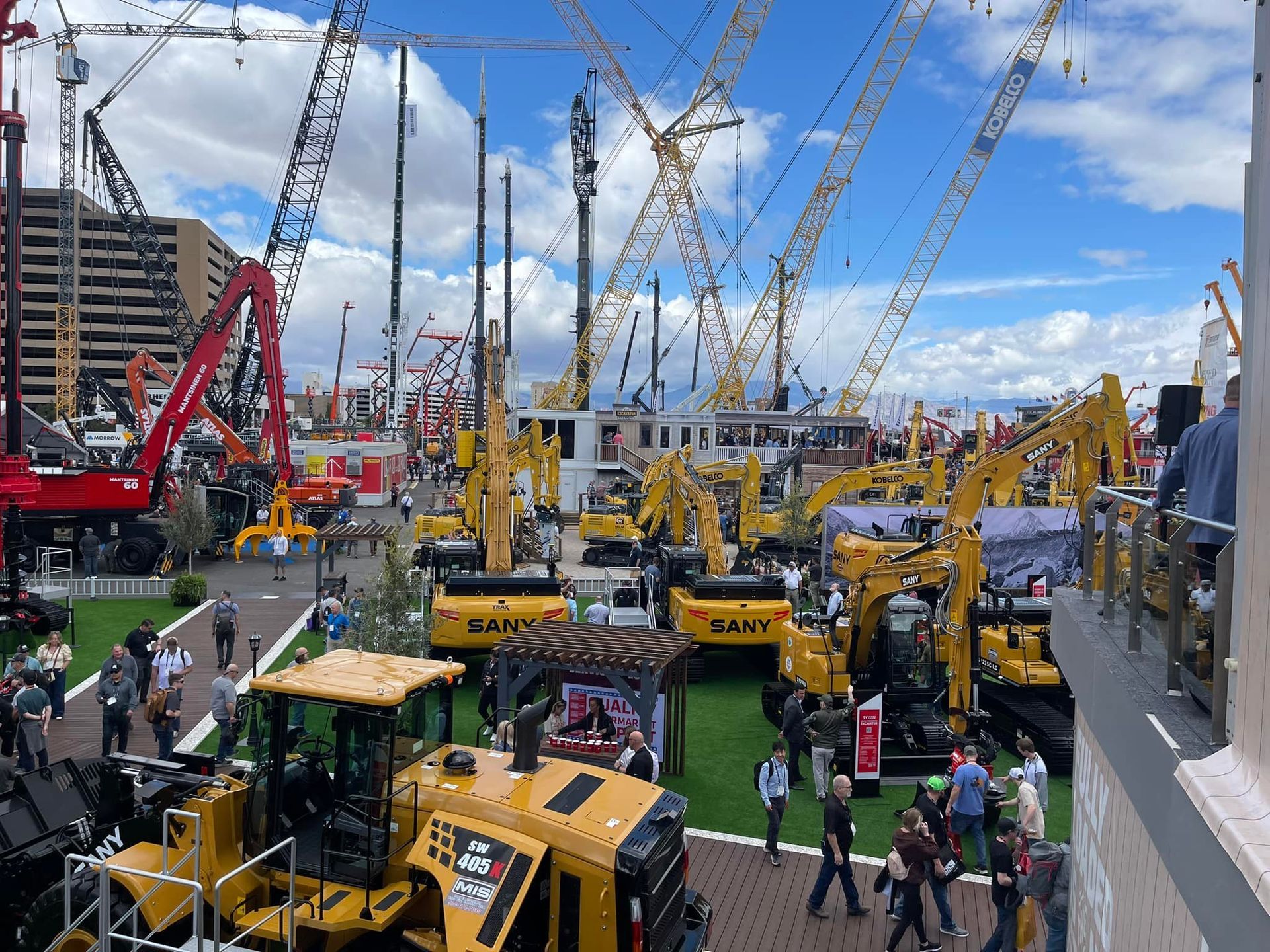 A large group of construction vehicles are parked in a parking lot.