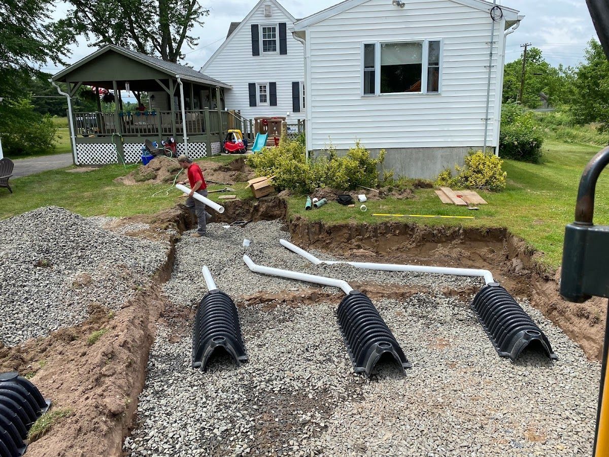 A septic system is being installed in front of a house.