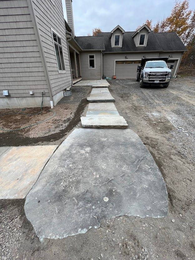 A concrete walkway is being built in front of a house.