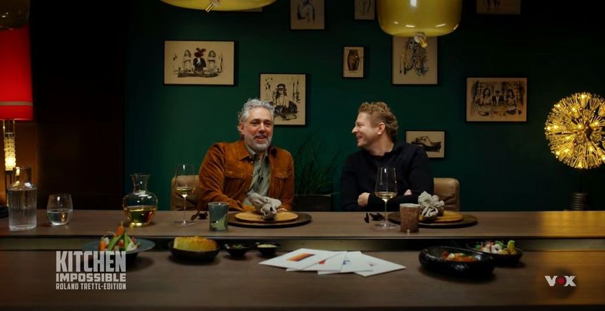 Staffel 11 von Kitchen Impossible auf VOX mit Tim Mälzer und Roland Trettl in einem atmosphärisch beleuchteten TV-Studio.