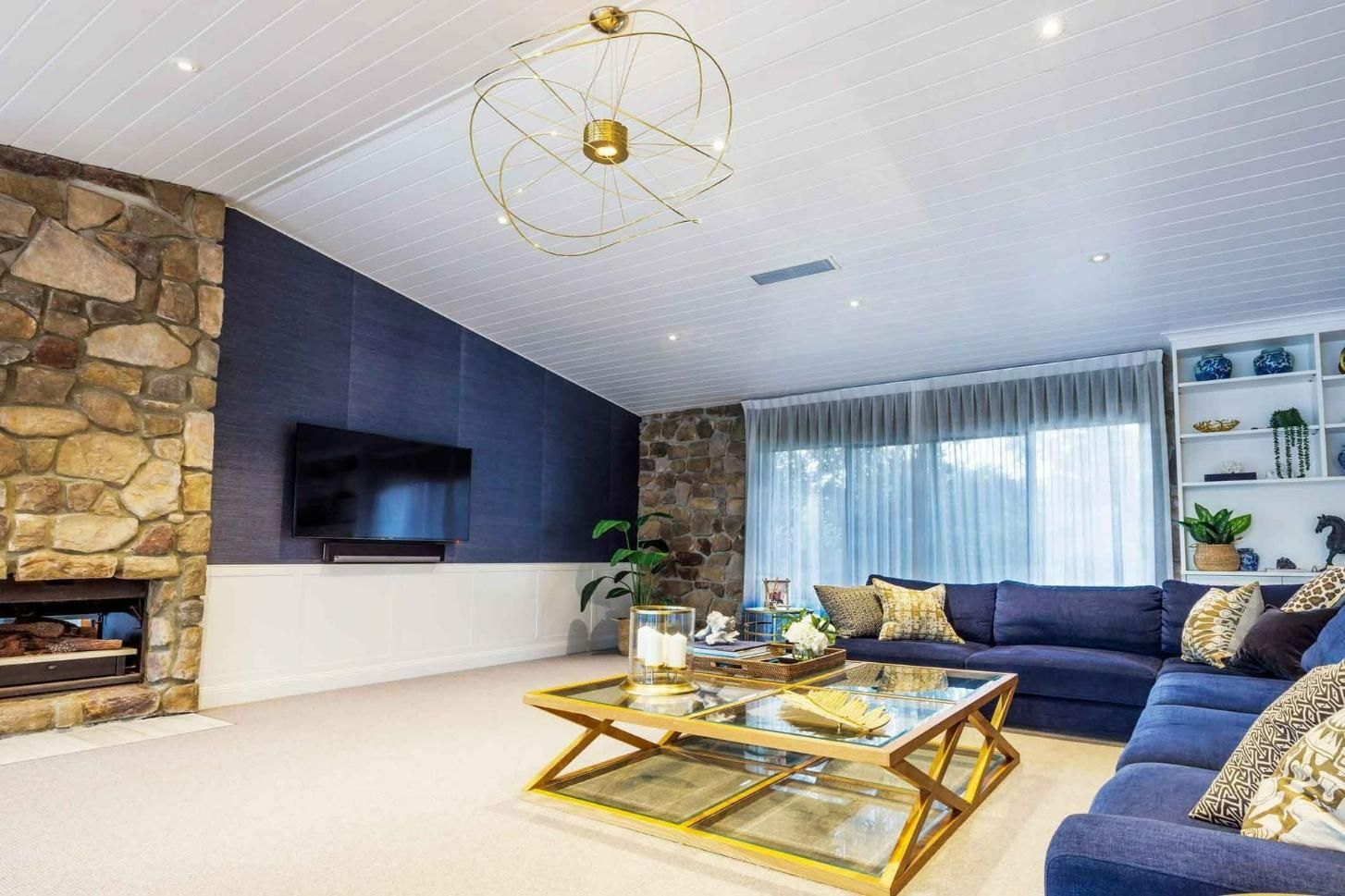 A Living Room With A Couch, Coffee Table, Television And Fireplace — Auslinc Building Services In Wingham, NSW