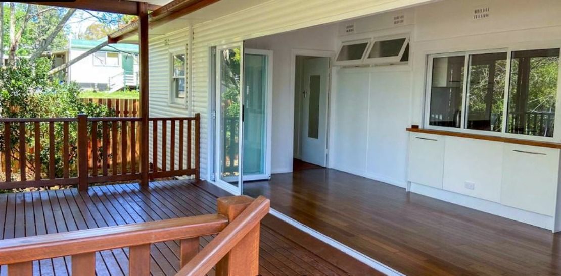 An Empty House With A Wooden Deck And Sliding Glass Doors — Auslinc Building Services In Wingham, NSW