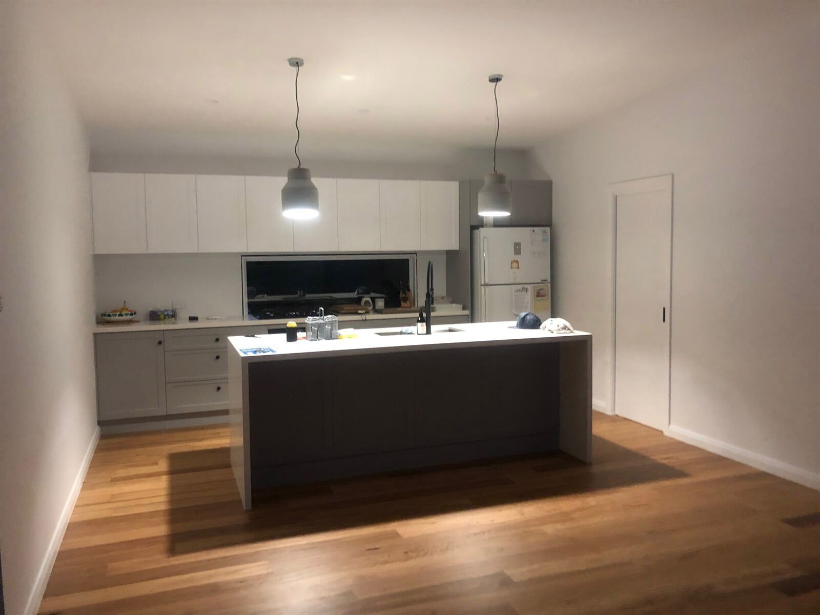 A Kitchen With A Large Island And White Cabinets — L.A.F Electrical P/L In Empire Bay, NSW