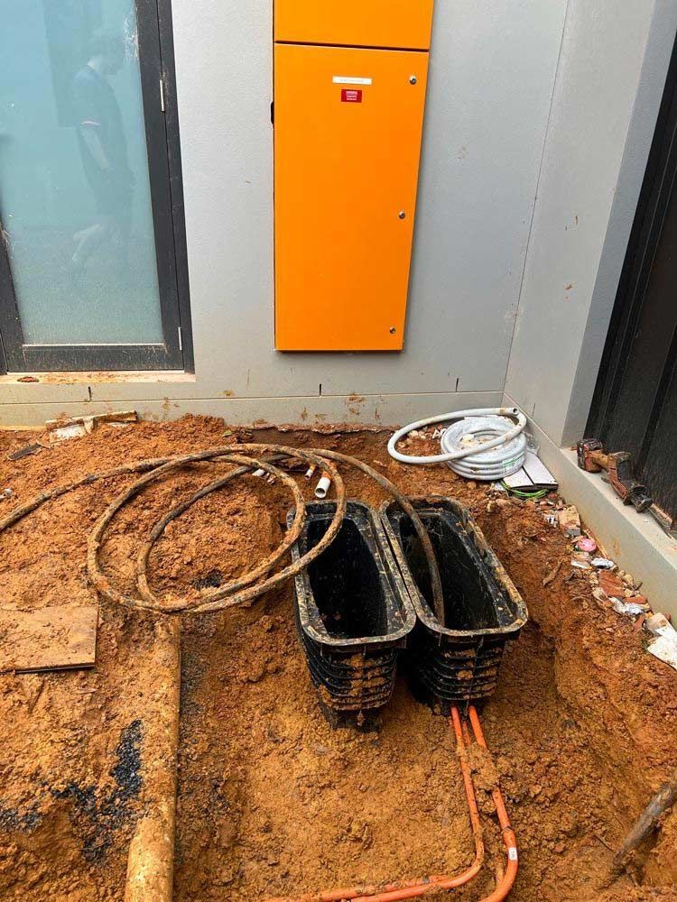 A Bunch Of Wires Are Laying In The Dirt In Front Of A Building — L.A.F Electrical P/L In Avoca Beach, NSW
