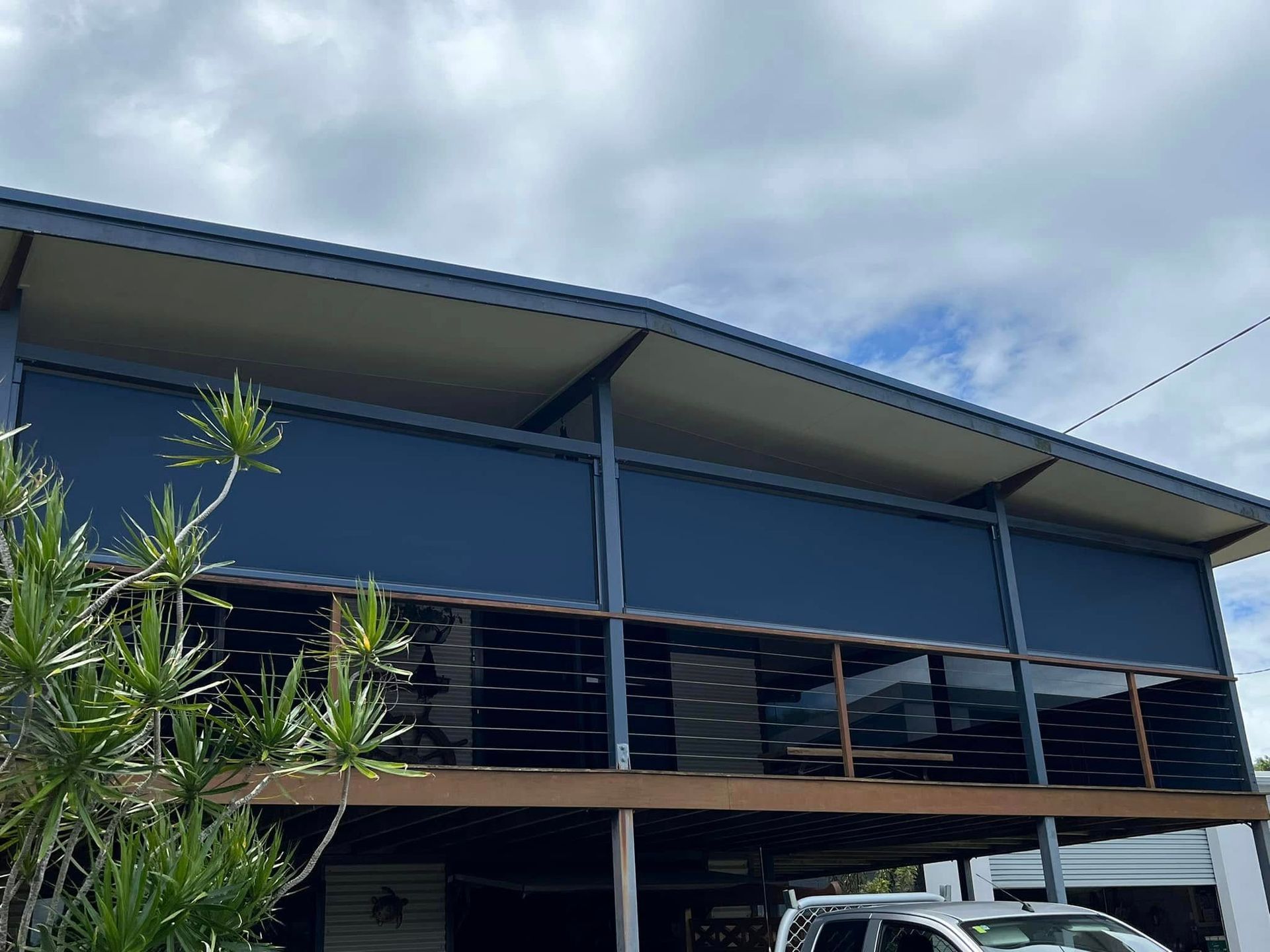 A Blue House With a Car Parked in Front — Whitsunday Blinds & Security In Beaconsfield, QLD