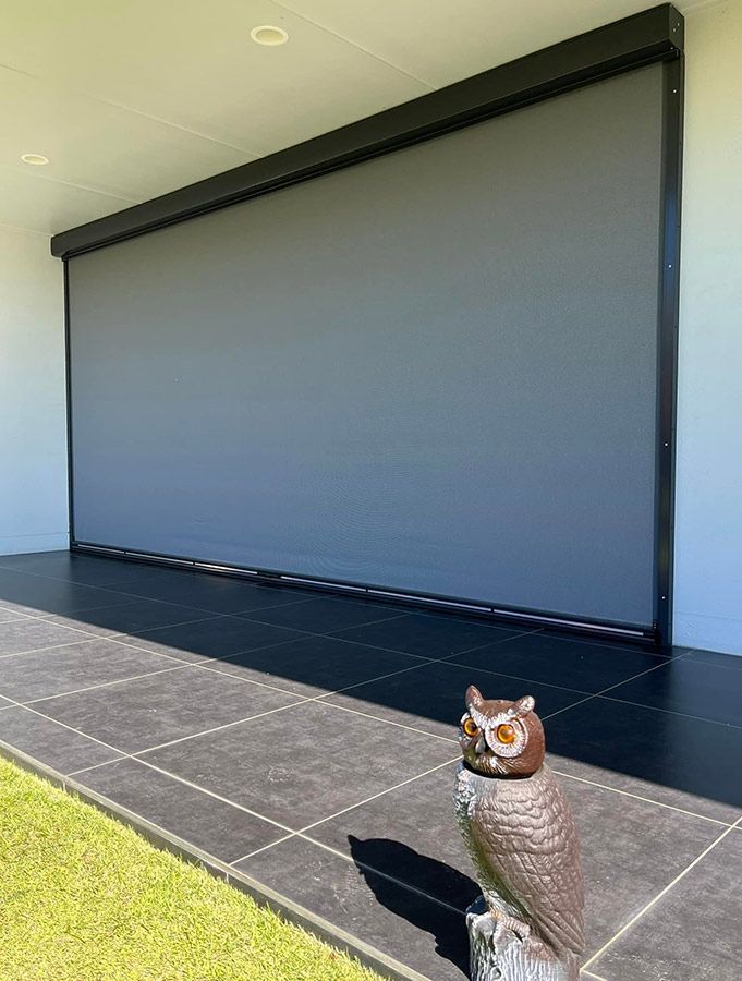 A Statue of an Owl is Sitting in Front of a Large Screen — Whitsunday Blinds & Security In Beaconsfield, QLD