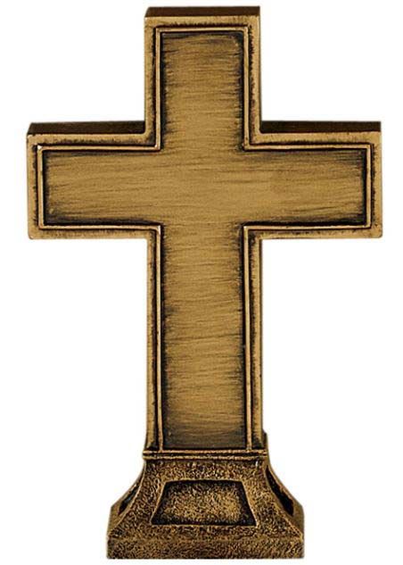 A small brass cross on a stand on a white background.